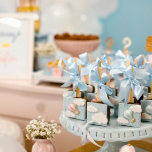 Elegant baby shower dessert table with pastel decorations and sweet treats.