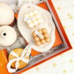 Elegant gift box featuring artistic vases, beads, and branded packaging for home decor.