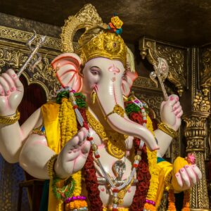 Intricate statue of Lord Ganesha adorned with vibrant garments and jewelry, capturing cultural richness.