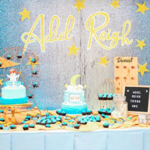 Colorful first birthday setup featuring a moon and stars theme with cakes and treats.