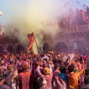 A lively Holi festival scene in Nandgaon, India, showcasing vivid colors and cultural traditions.