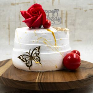 Stylish white cake decorated with a red rose, butterfly, and birthday message, perfect for celebrations.