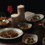 A luxurious dining table setup with gourmet dishes and candlelight mood.