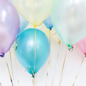 Pastel balloons floating against a neutral background, perfect for festive events.