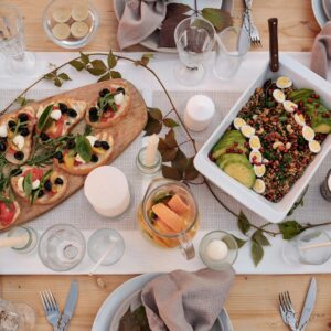 Stylish dinner setup featuring bruschetta and quinoa salad with avocado and eggs, perfect for celebrations.