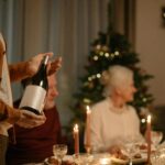 Cozy family gathering around a dinner table during the Christmas season with wine and festive decorations.