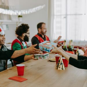 Group of coworkers exchanging gifts at an office Christmas party, spreading joy and holiday cheer.