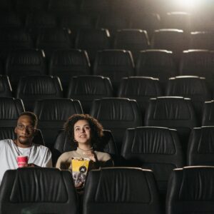 A couple enjoying drinks and snacks during a movie night in an empty cinema.