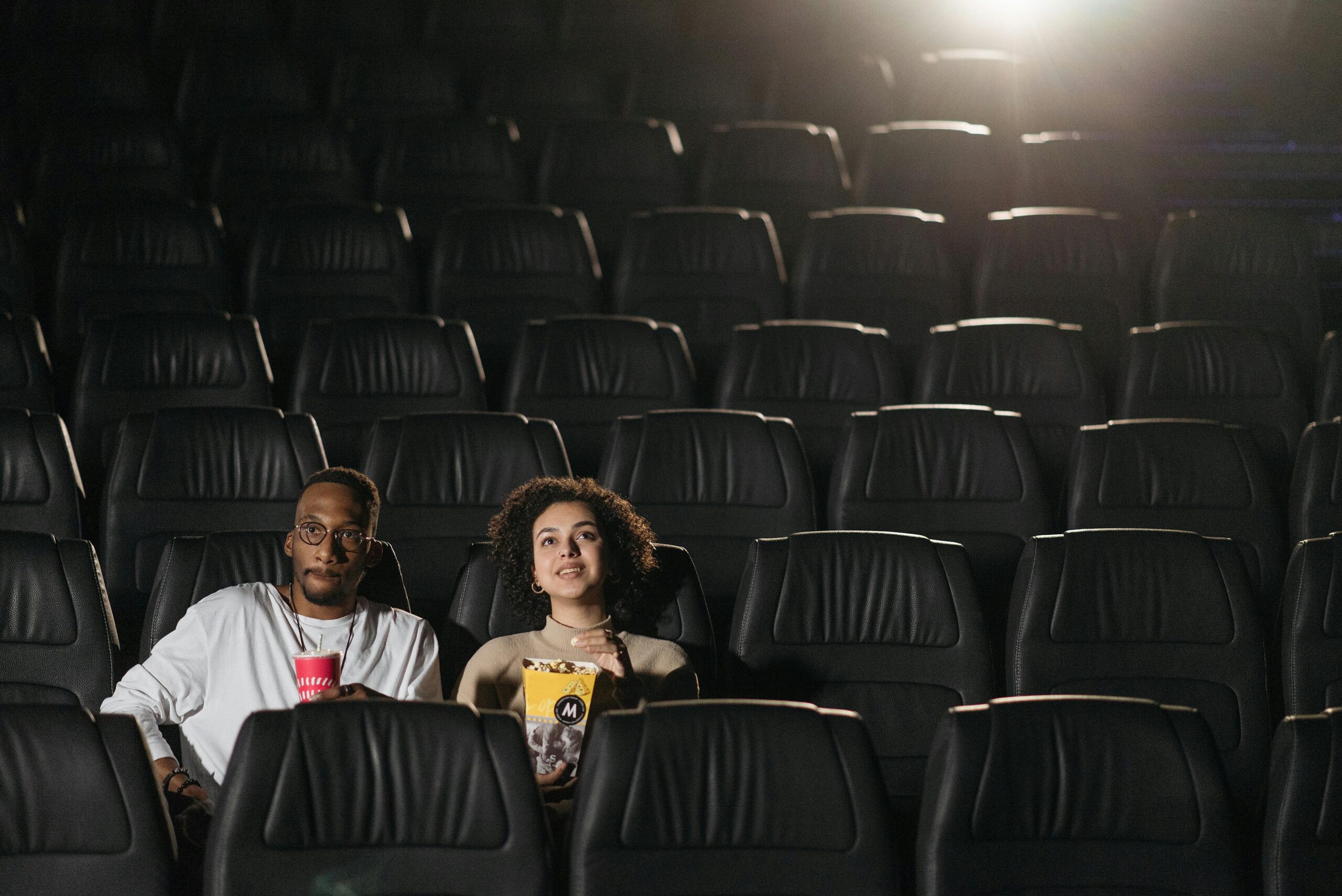 pexels photo 7234321 7234321 A couple enjoying drinks and snacks during a movie night in an empty cinema.