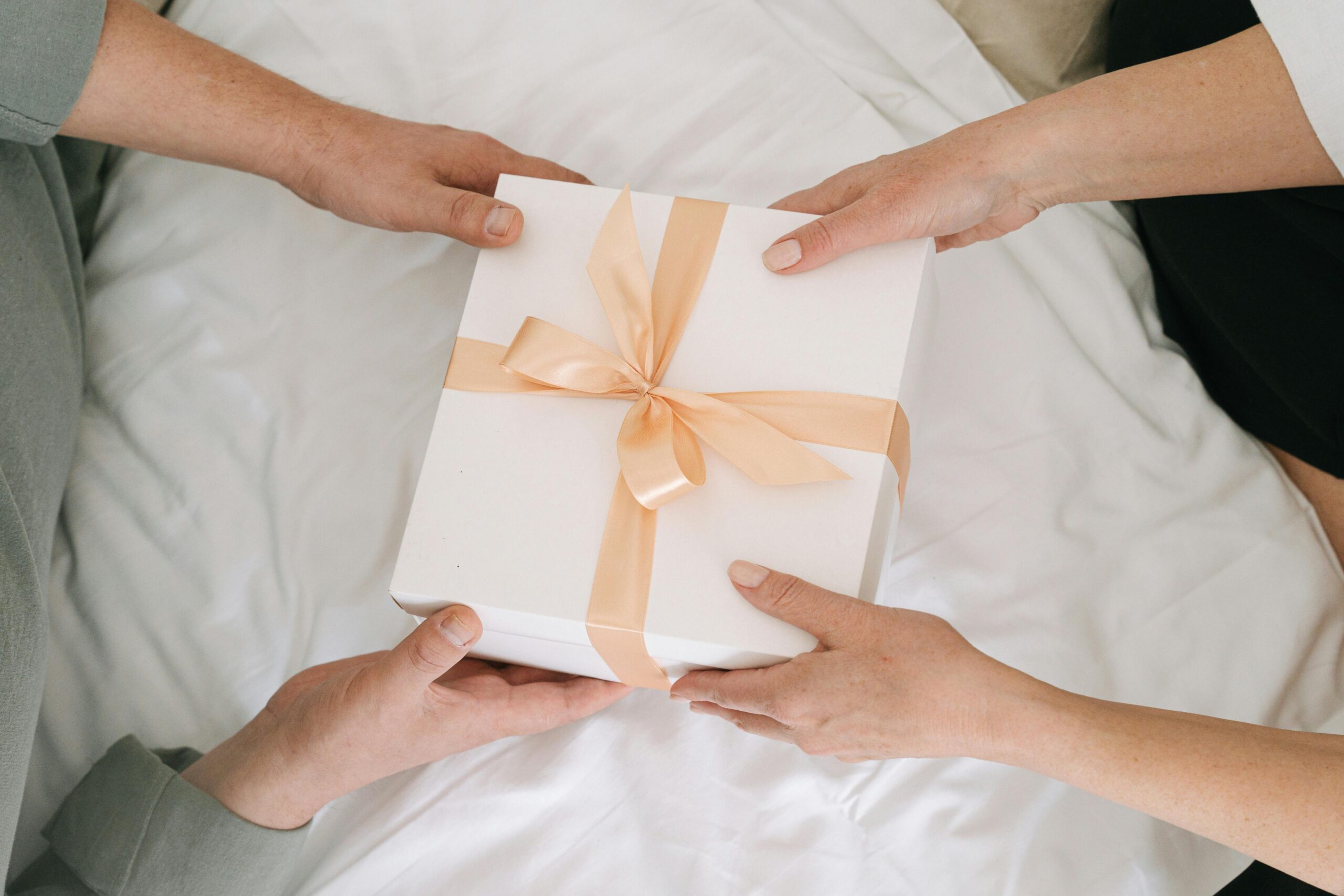 pexels photo 7910649 7910649 Hands exchanging a beautifully wrapped gift box, symbolizing celebration and sharing.