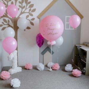 A delightful children's birthday setup with pink balloons and playful decorations in a cozy room.